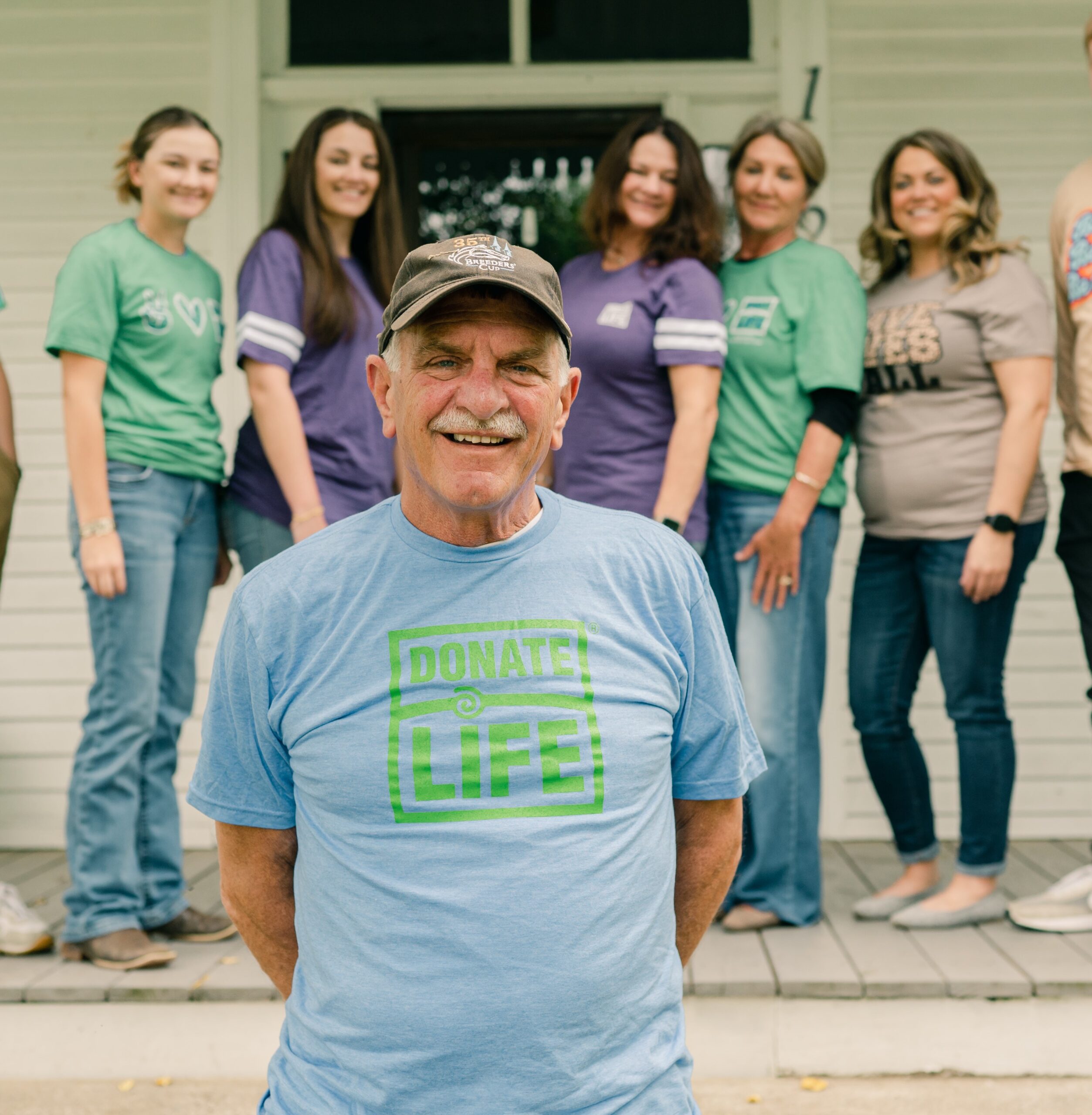 Eddie Wells standing in front of family on porch