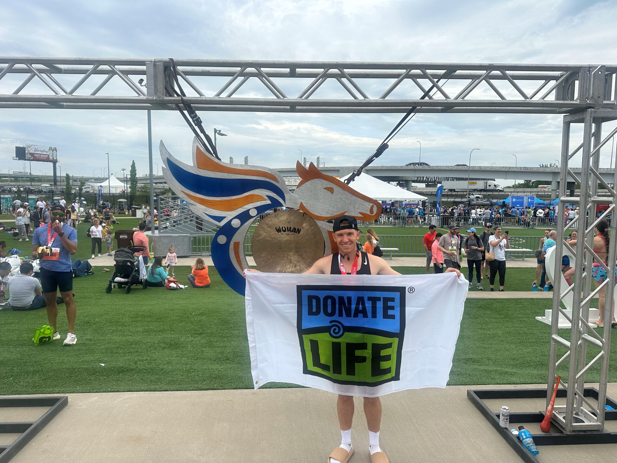 Ryan Harris holding a Donate Life flag at KDF Marathon finish line